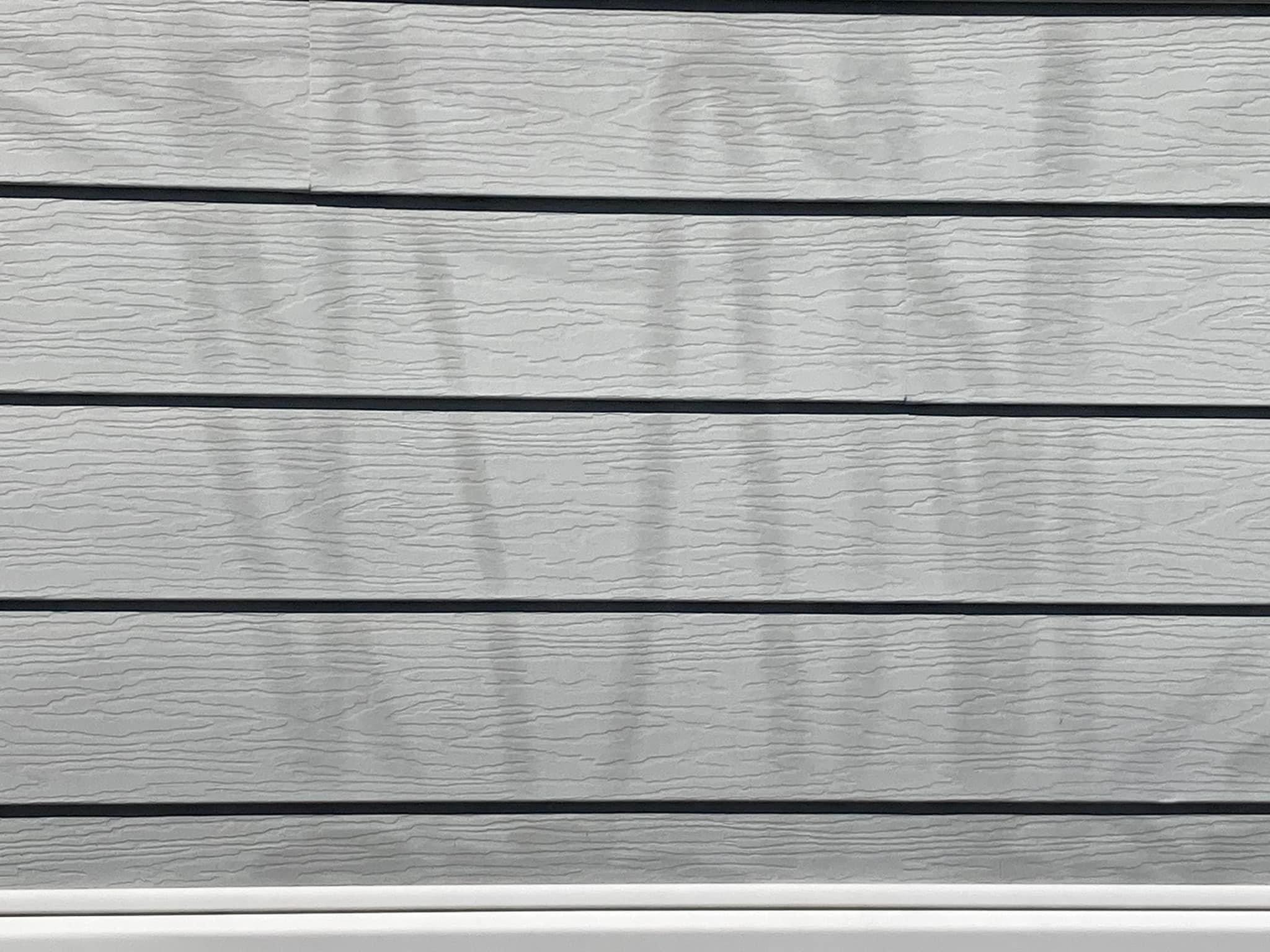 Close-up of shadow marks where high pressure unevenly stripped oxidized siding