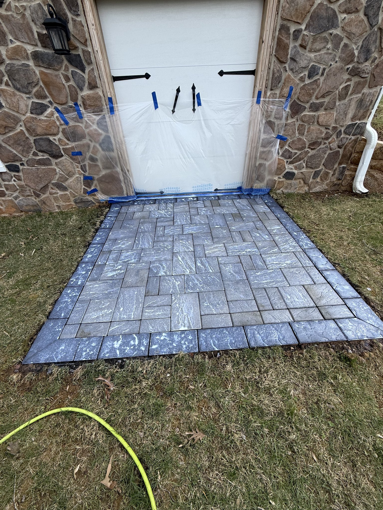 Wet-look sealer freshly applied to the garage entry paver pad