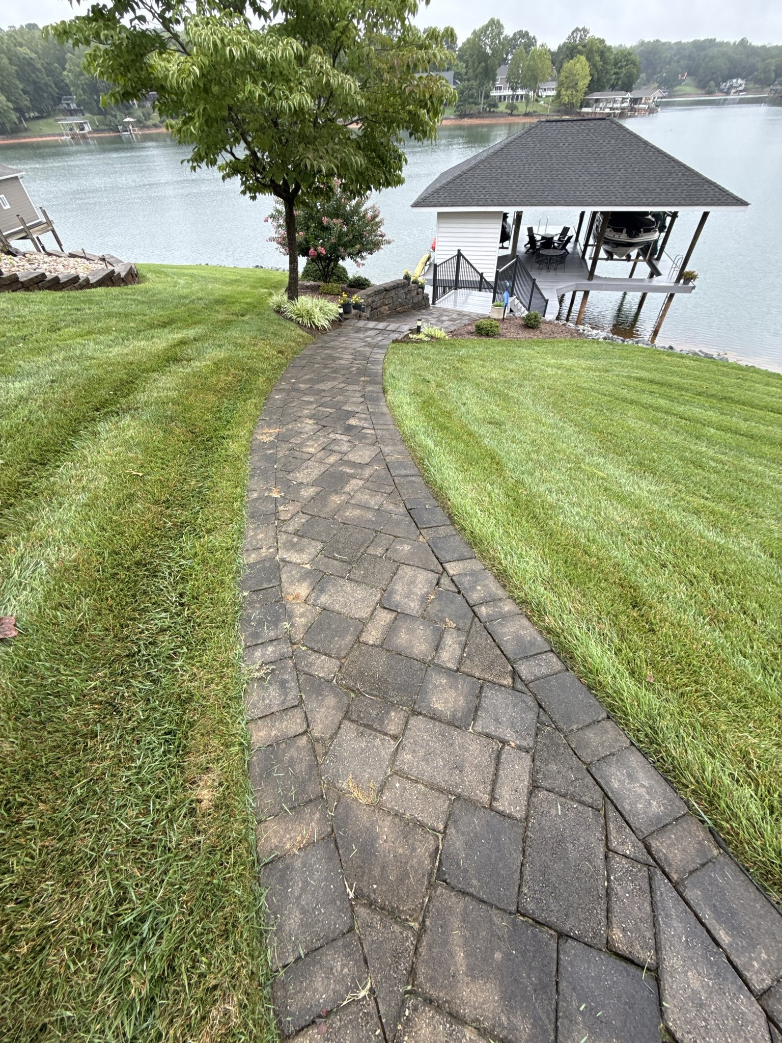 Paver walkway darkened by mold and algae leading down to the dock and boathouse at Smith Mountain Lake in Huddleston, VA
